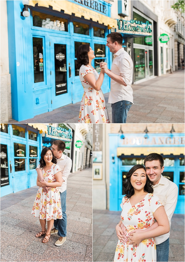 An engagement session in downtown Salt Lake City. The couple is standing in front of a bakery with a french design to it. The couple is hugging, laughing, and smiling at the camera.