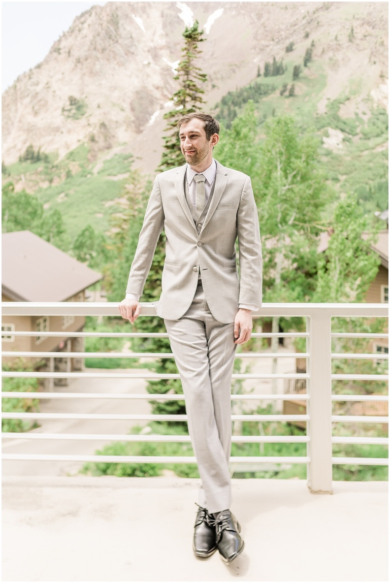 groom on balcony with little cottonwood canyon in background